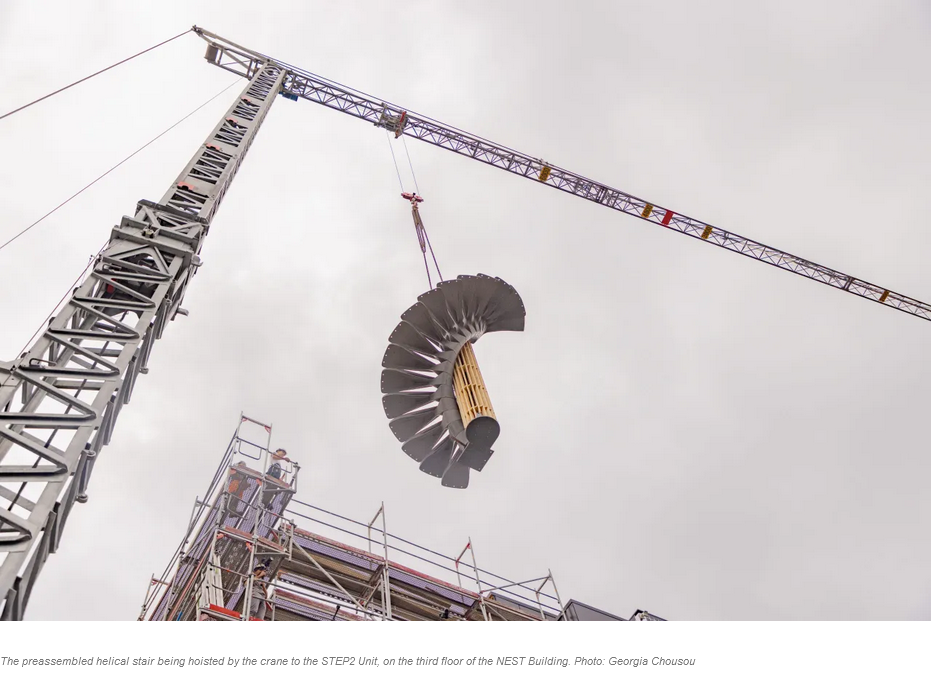 The preassembled helical stair being hoisted by the crane to the STEP2 Unit, on the third floor of the NEST Building. Photo: Georgia Chousou